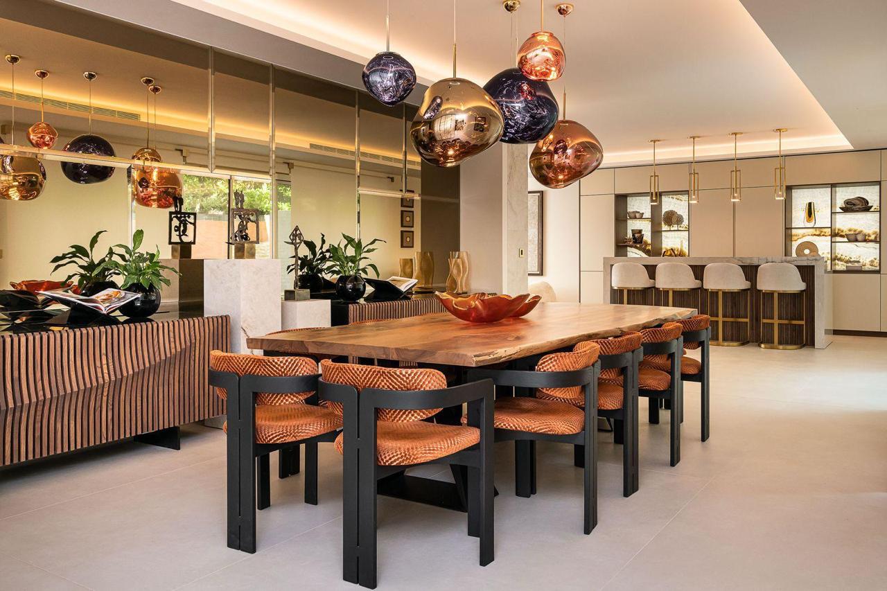 Open plan dining and kitchen at Warbank Lane with Melt chandelier by Tom Dixon above a raw edge dining table